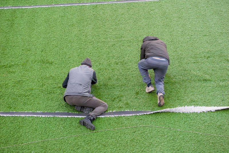 two specialists installing artificial grass lawn